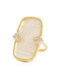 Gold ring with pearl-like center and diamond-like accents on a beige background