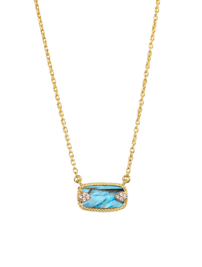 Gold necklace with a blue gemstone pendant on a light beige background