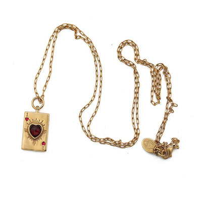 Gold necklace with heart pendant and small rectangular pendants on a white background
